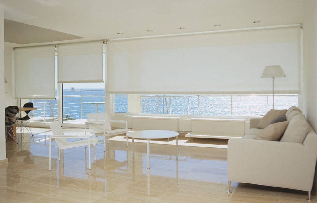 Salón con cortinas enrollables y vistas al mar